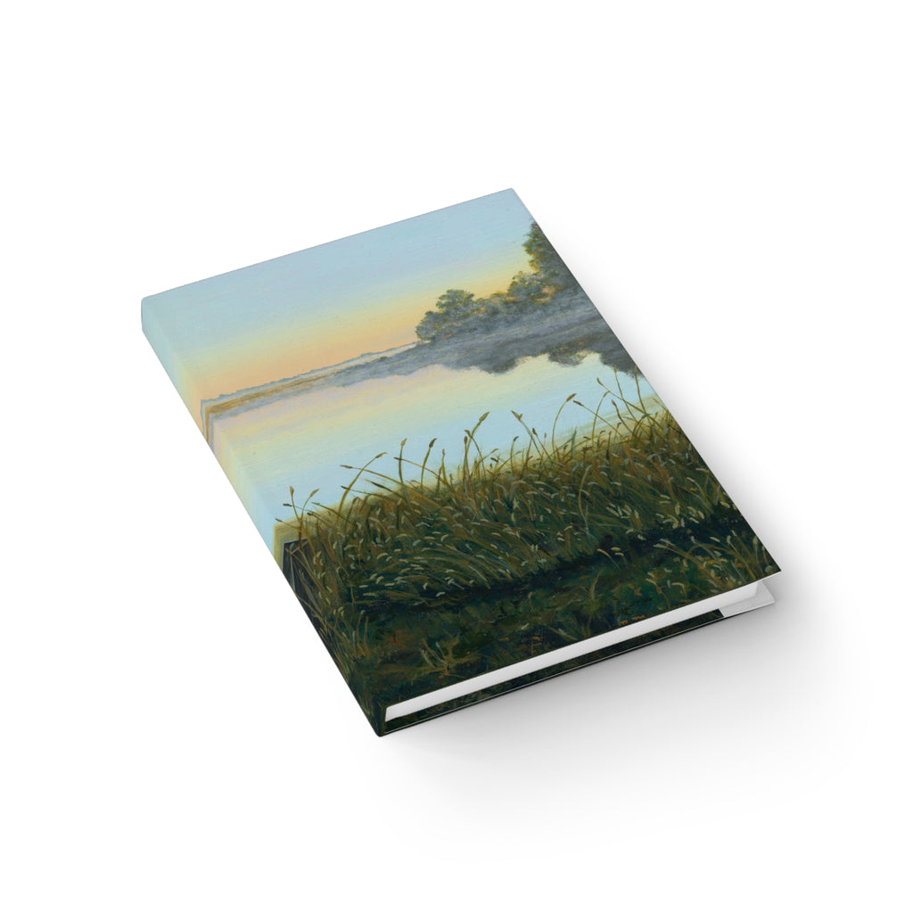 Notebook with a scenic cover of a lake and grass on a white background